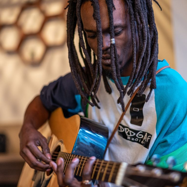 focused black man playing guitar in studio